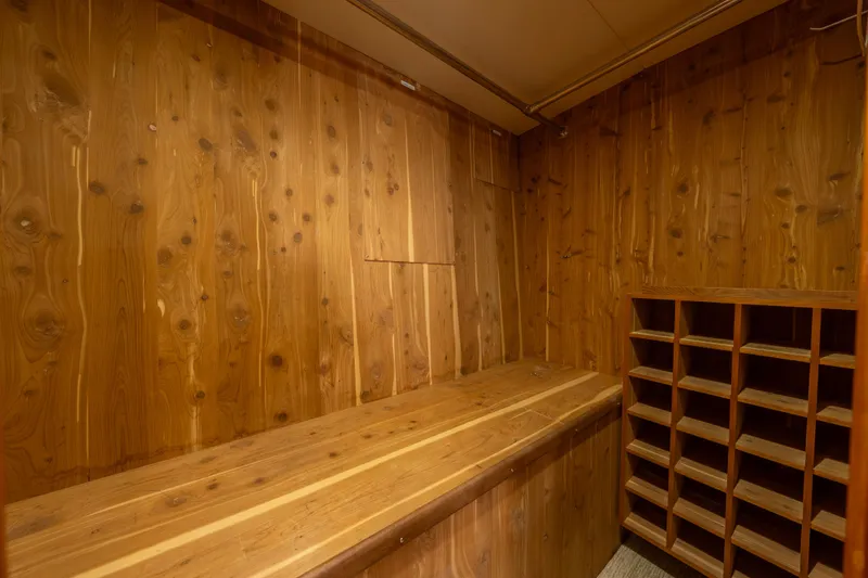 Slide: The Image of Wood-paneled storage area with shelving on a 2004 Hatteras 75 Sport Deck Motor Yacht. - 14