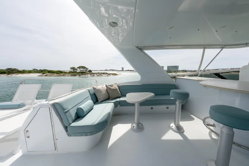 Slide: The Image of Luxurious 2004 Hatteras 75 Sport Deck Motor Yacht with elegant seating and scenic ocean view. - 32