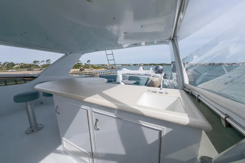 Slide: The Image of 2004 Hatteras 75 Sport Deck Motor Yacht interior with bar and sink, overlooking water. - 34