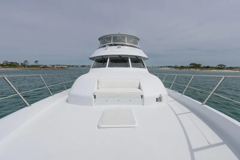 Slide: The Image of 2004 Hatteras 75 Sport Deck Motor Yacht on open water, featuring spacious deck and seating. - 39