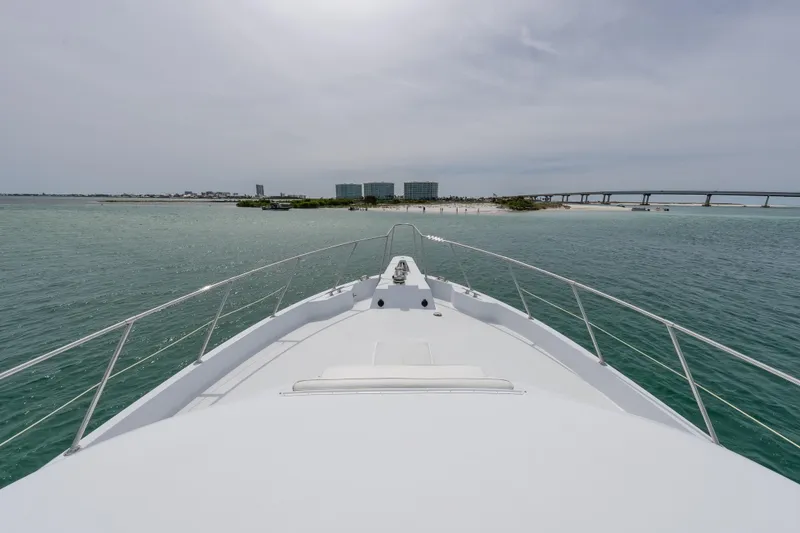 Slide: The Image of Bow view of 2004 Hatteras 75 Sport Deck Motor Yacht approaching a scenic shoreline. - 40