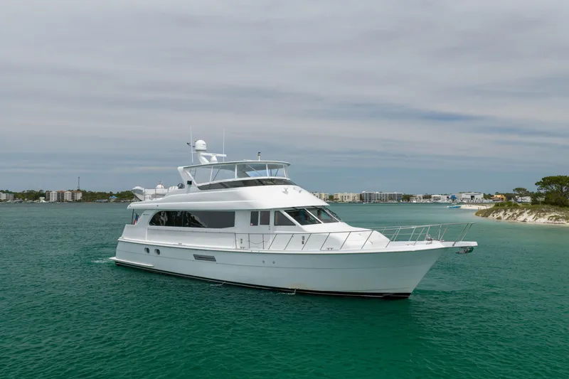 Slide: The Image of 2004 Hatteras 75 Sport Deck Motor Yacht cruising in clear turquoise waters. - 50