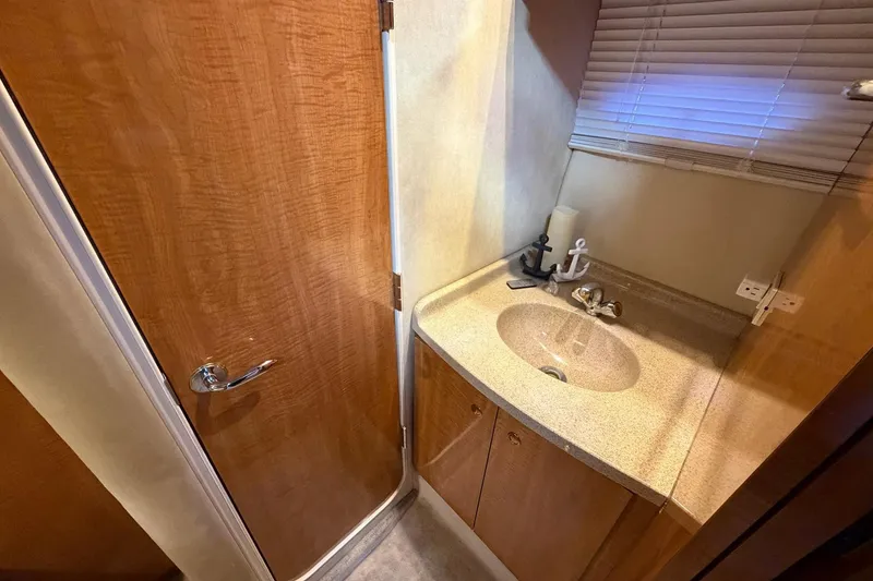 Slide: The Image of 2002 Regal Commodore 3860 yacht bathroom with wooden door and countertop sink. - 30