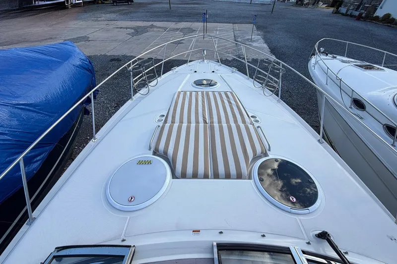 Slide: The Image of 2002 Regal Commodore 3860 yacht deck with striped sun pad and circular hatches. - 16