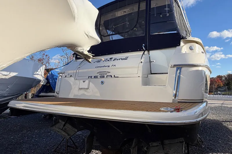 Slide: The Image of 2002 Regal Commodore 3860 yacht docked, rear view with clear sky background. - 4