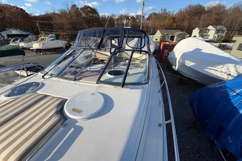 Slide: The Image of 2002 Regal Commodore 3860 yacht in storage, surrounded by other boats and autumn trees. - 21