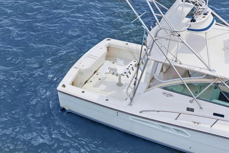 Slide: The Image of 2005 Rampage 38 Express boat on blue ocean water, featuring spacious deck and fishing equipment. - 12