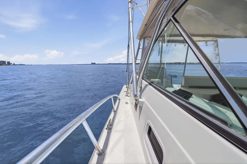 Slide: The Image of 2005 Rampage 38 Express yacht cruising on open blue sea under clear sky. - 17