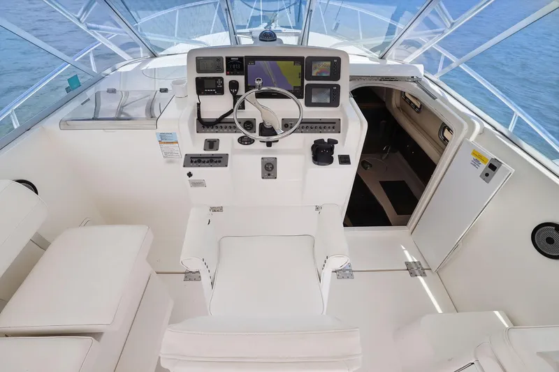 Slide: The Image of Cockpit of 2005 Rampage 38 Express boat with steering wheel and navigation equipment. - 27