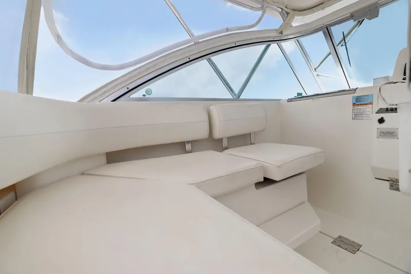 Slide: The Image of 2005 Rampage 38 Express boat interior with white seating and clear canopy. - 32