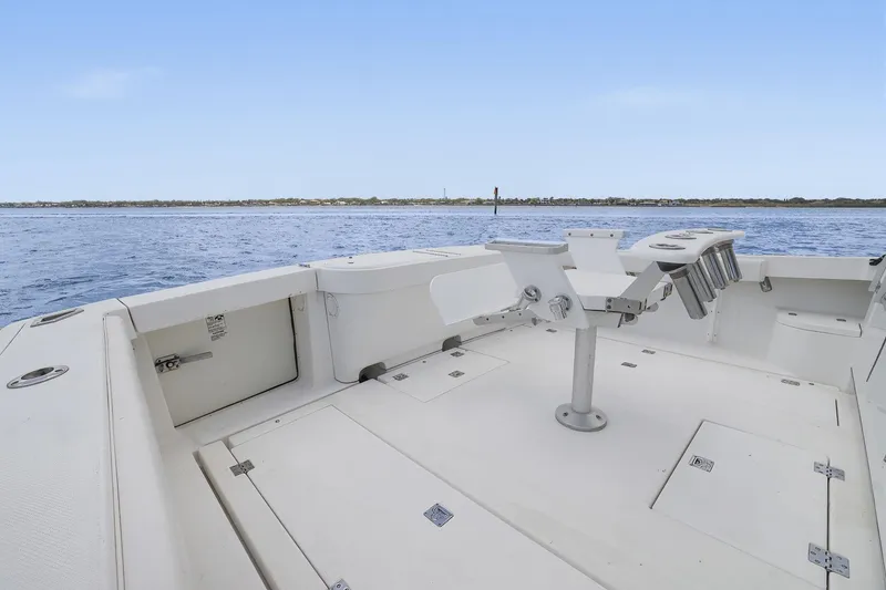 Slide: The Image of 2005 Rampage 38 Express boat deck with rod holders, overlooking calm waters. - 38