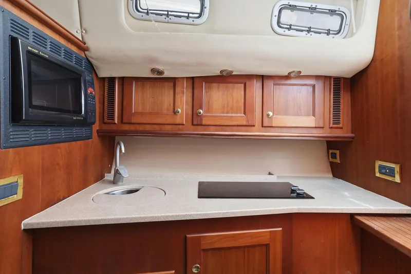 Slide: The Image of 2005 Rampage 38 Express yacht kitchen with microwave, sink, and wooden cabinets. - 55
