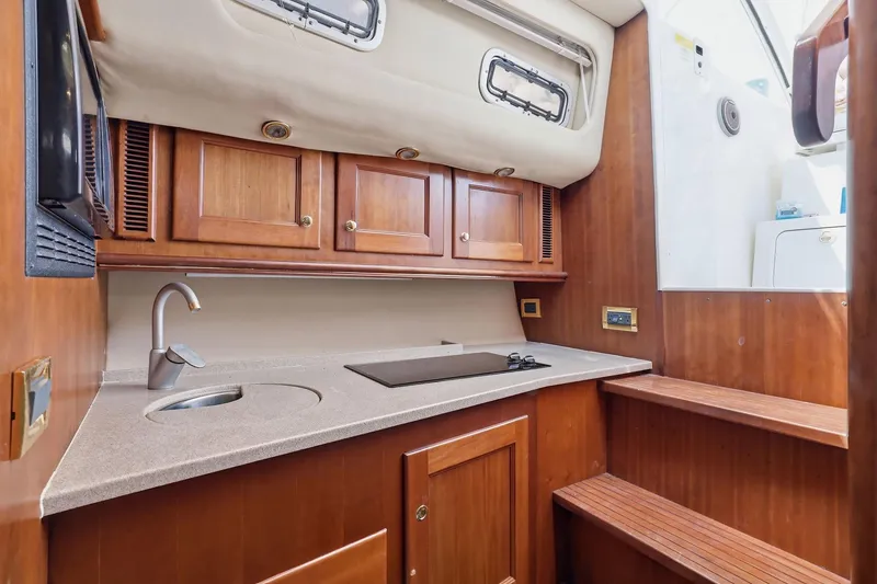 Slide: The Image of 2005 Rampage 38 Express yacht interior with wooden cabinets and compact kitchen area. - 56