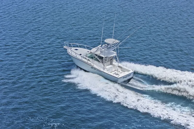 Slide: The Image of 2005 Rampage 38 Express boat cruising on open water, creating a wake. - 6
