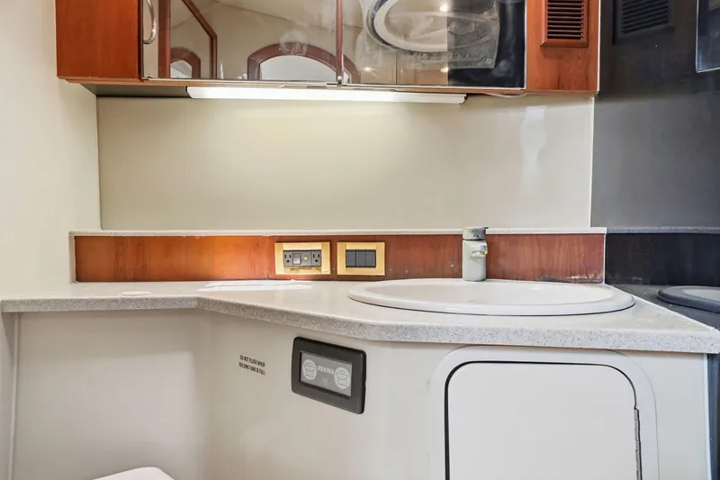 Slide: The Image of 2005 Rampage 38 Express yacht bathroom with sink, mirror, and wooden cabinetry. - 65