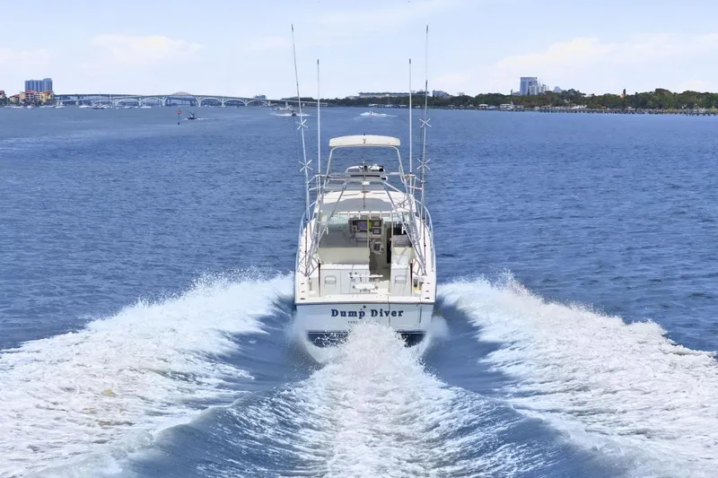 Slide: The Image of 2005 Rampage 38 Express boat cruising on open water with cityscape in background. - 8