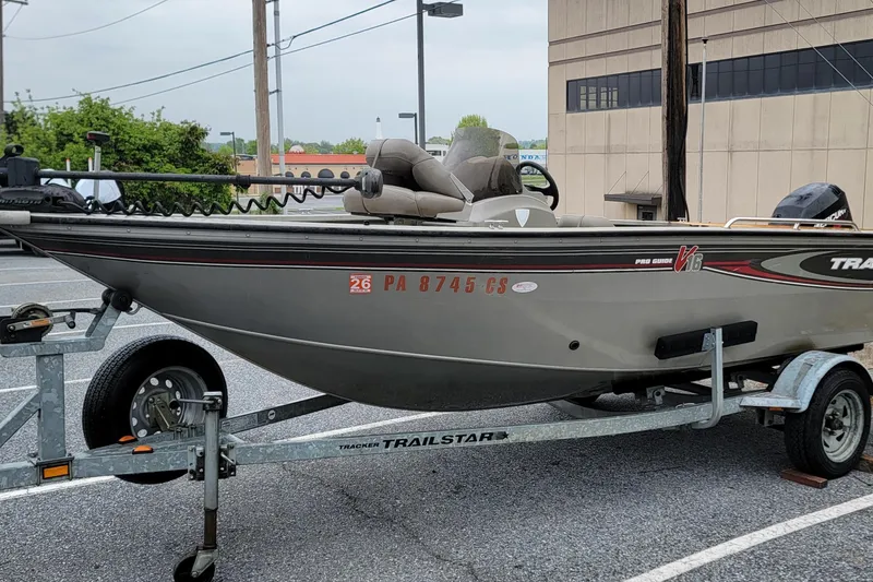 Slide: The Image of 2004 Tracker Pro Deep V-16 Single Console boat on a trailer in a parking lot. - 2