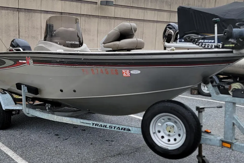 Slide: The Image of 2004 Tracker Pro Deep V-16 Single Console boat on a trailer in a parking lot. - 6