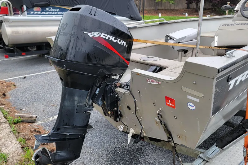 Slide: The Image of 2004 Tracker Pro Deep V-16 boat with Mercury outboard motor in a parking lot. - 7