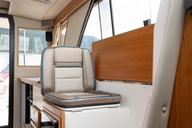 Slide: The Image of Manufacturer Provided Image: 2022 Cutwater C-32 CB interior helm seat with modern design and panoramic windows. - 11