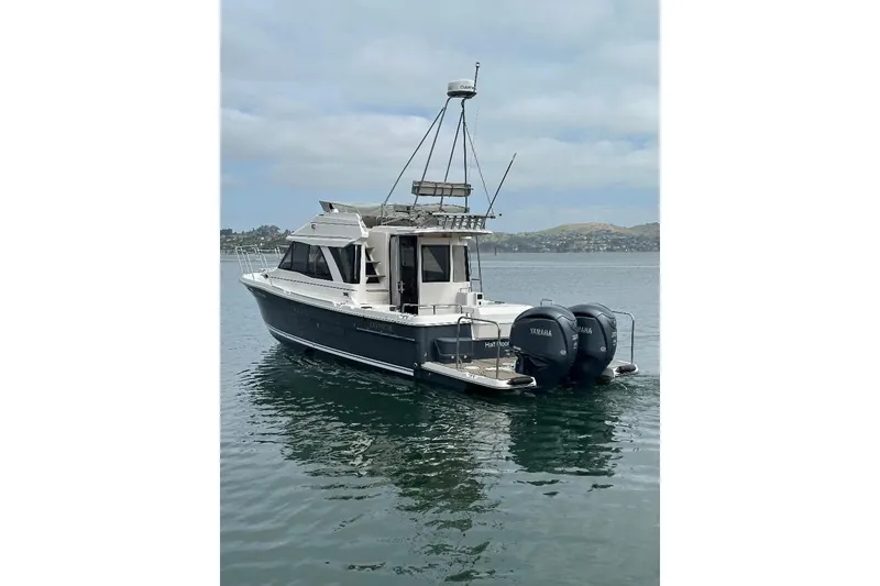 Slide: The Image of 2022 Cutwater C-32 CB boat with twin Yamaha engines on calm water. - 2