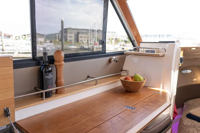 Slide: The Image of Interior of 2022 Cutwater C-32 CB yacht with wooden counter, wine, and fruit bowl. - 8