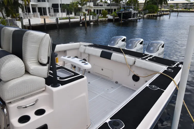 Slide: The Image of 2010 Grady-White Canyon 366 boat with triple Suzuki engines docked by waterfront homes. - 17
