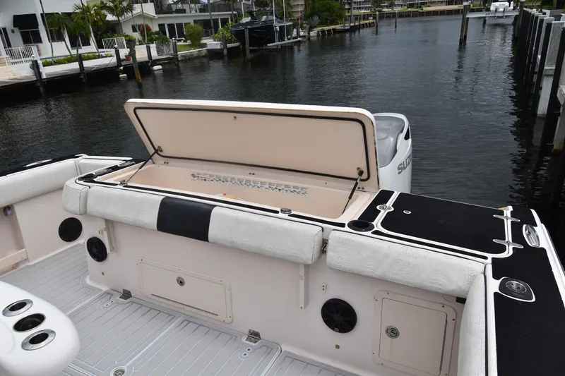 Slide: The Image of 2010 Grady-White Canyon 366 boat with open storage compartment, docked by waterfront homes. - 22