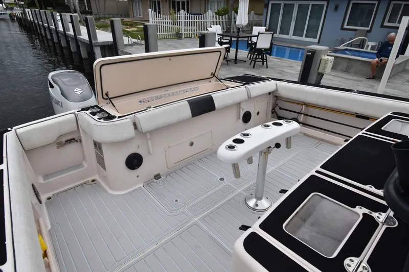 Slide: The Image of 2010 Grady-White Canyon 366 boat deck with seating and rod holders, docked by waterfront homes. - 23