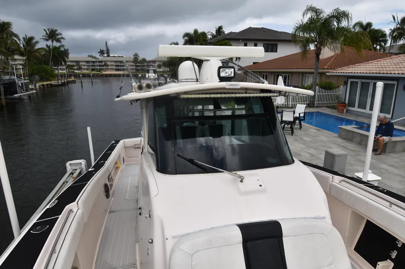 Slide: The Image of 2010 Grady-White Canyon 366 boat docked near waterfront homes and palm trees. - 9