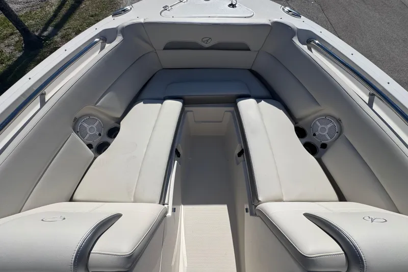 Slide: The Image of 2023 Sailfish 245 DC boat interior with cushioned seating and built-in speakers. - 13