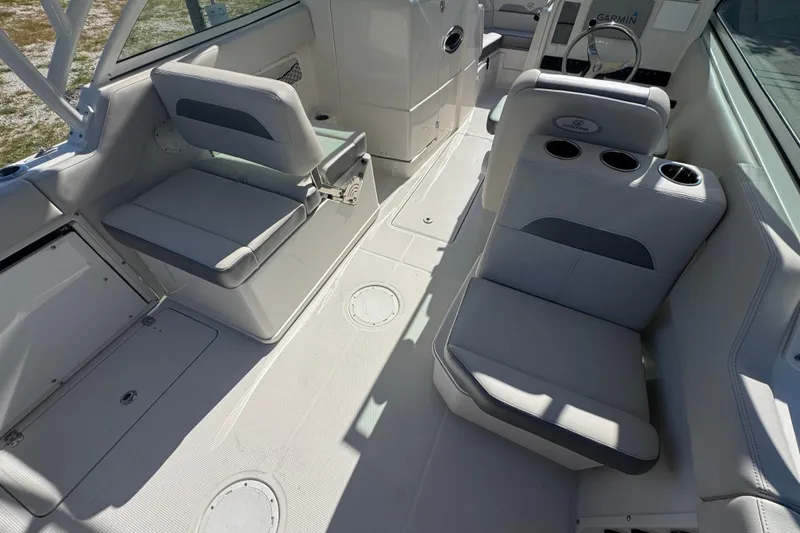 Slide: The Image of 2023 Sailfish 245 DC boat interior with seating and steering console. - 5