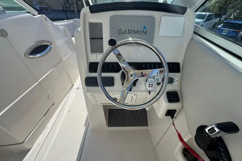 Slide: The Image of 2023 Sailfish 245 DC boat helm with Garmin navigation system and steering wheel. - 9
