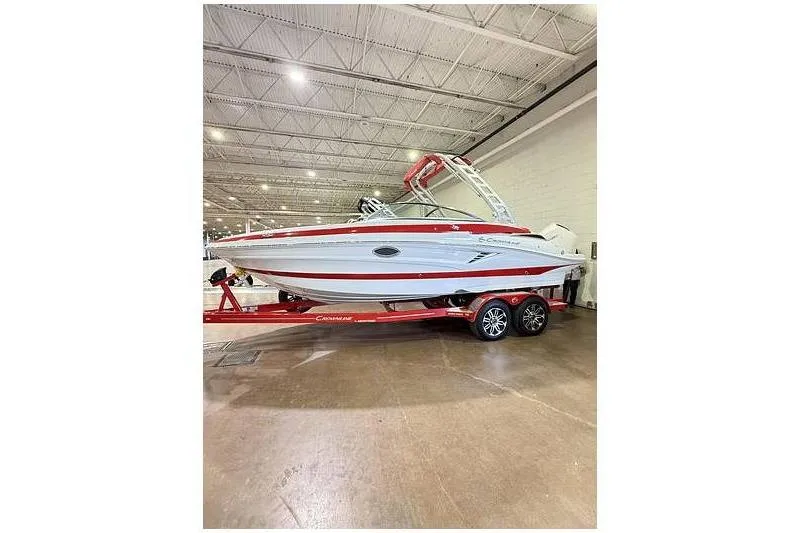 The Image of 2024 Crownline 250 XSS boat on red trailer in indoor showroom. - 1