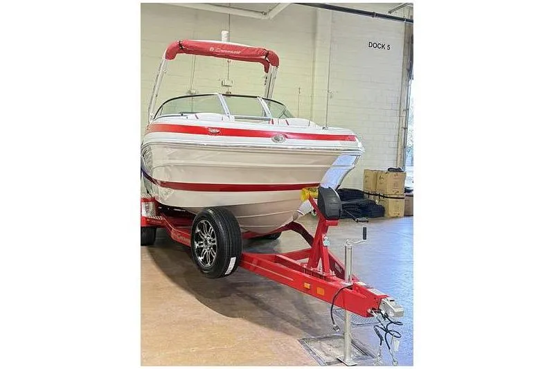 Slide: The Image of 2024 Crownline 250 XSS boat on red trailer in indoor dock setting. - 5