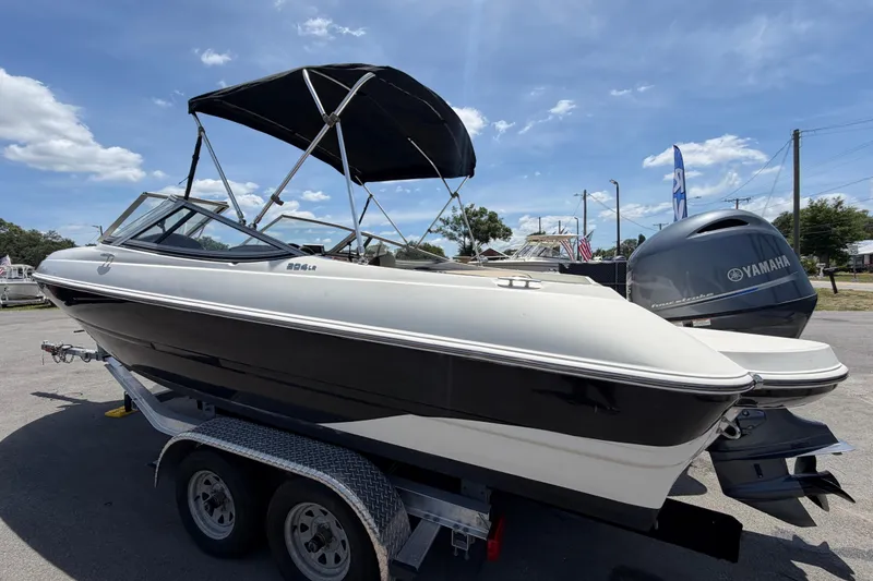 Slide: The Image of 2018 Stingray 204 LR boat on trailer with Yamaha outboard motor, under clear blue sky. - 5