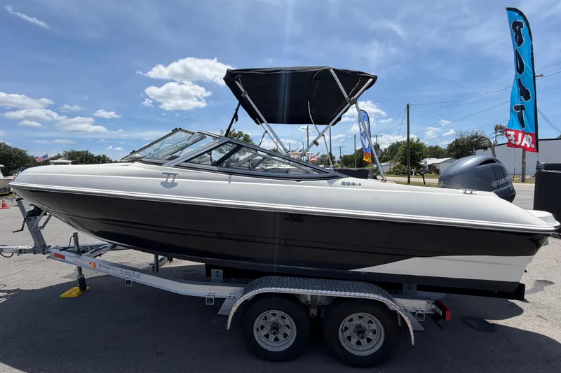 Slide: The Image of 2018 Stingray 204 LR boat on trailer under clear blue sky. - 6