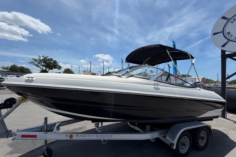 Slide: The Image of 2018 Stingray 204 LR boat on trailer under clear blue sky. - 7