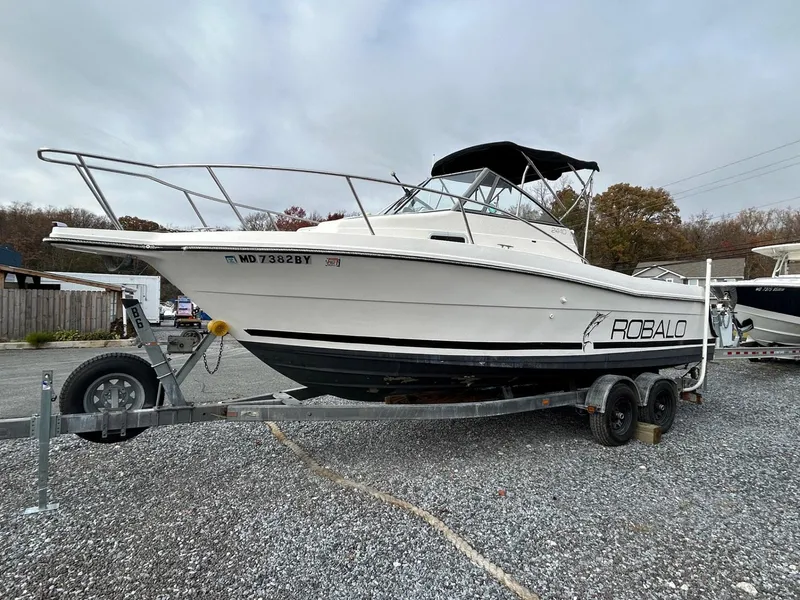 The Image of 1996 Robalo 2440 Walkaround boat on trailer, parked outdoors. - 1