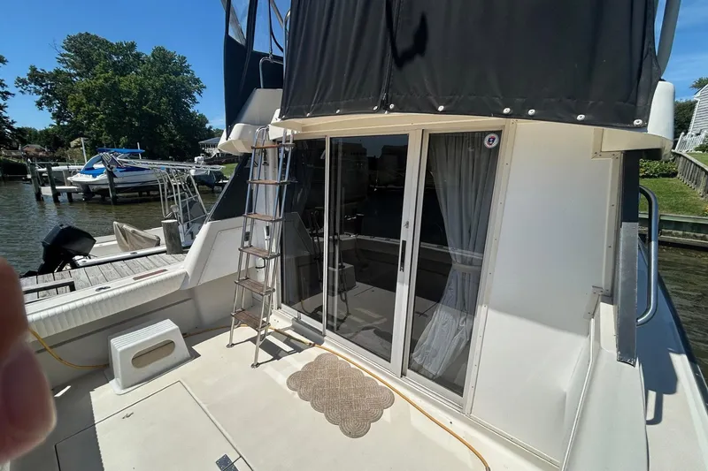 Slide: The Image of 1990 Silverton 34 Convertible yacht with sliding glass doors and docked at a marina. - 7