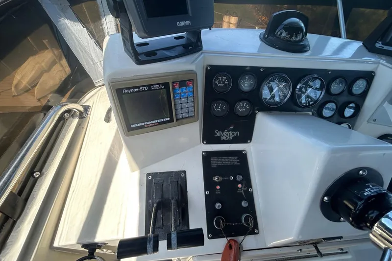 Slide: The Image of 1990 Silverton 34 Convertible yacht dashboard with navigation and control instruments. - 13