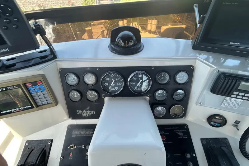 Slide: The Image of Control panel of a 1990 Silverton 34 Convertible yacht with gauges and navigation equipment. - 14