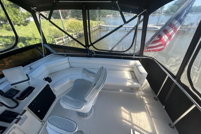 Slide: The Image of Interior view of 1990 Silverton 34 Convertible boat with white seating and helm. - 10