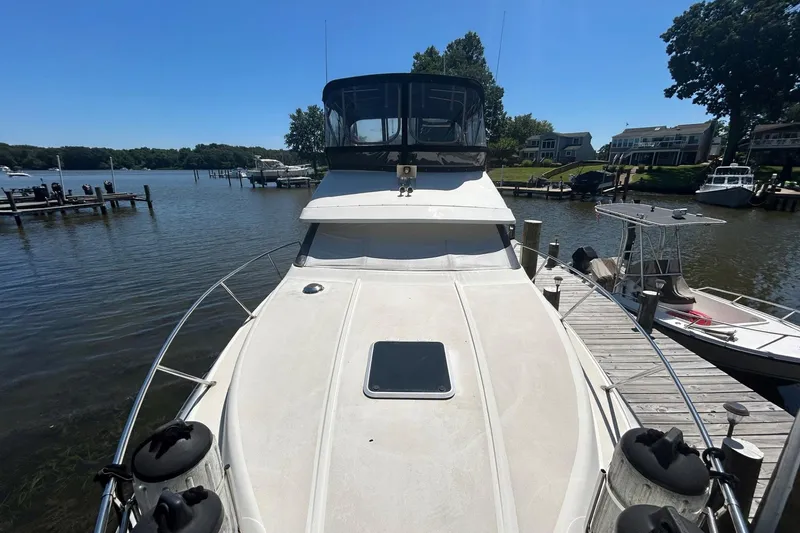 Slide: The Image of 1990 Silverton 34 Convertible yacht docked at a marina on a sunny day. - 34