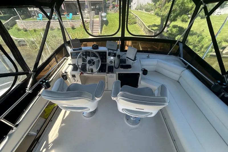 Slide: The Image of 1990 Silverton 34 Convertible boat helm with dual seats and navigation equipment. - 11