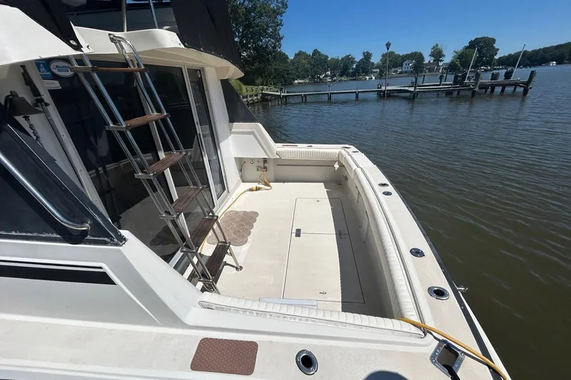Slide: The Image of 1990 Silverton 34 Convertible boat docked by a serene waterfront. - 5