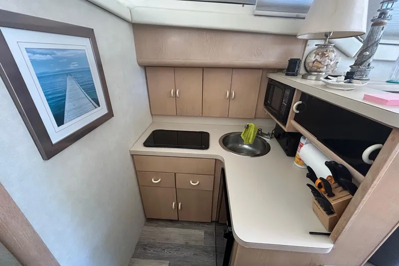 Slide: The Image of Compact kitchen in 1990 Silverton 34 Convertible boat with modern amenities and decor. - 24