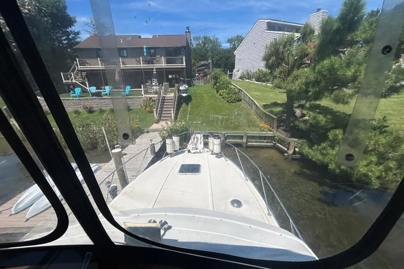 Slide: The Image of 1990 Silverton 34 Convertible boat docked near waterfront homes, viewed from the helm. - 18