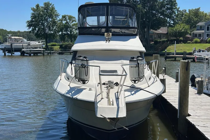 Slide: The Image of 1990 Silverton 34 Convertible boat docked at a marina, surrounded by trees and water. - 1
