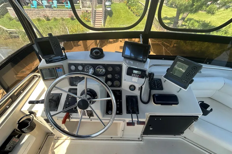 Slide: The Image of 1990 Silverton 34 Convertible boat helm with navigation equipment and steering wheel. - 12